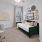 a living room with a green daybed and desk